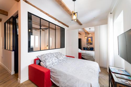 une chambre avec un lit et une chaise rouge dans l'établissement French riviera old town heart, à Nice