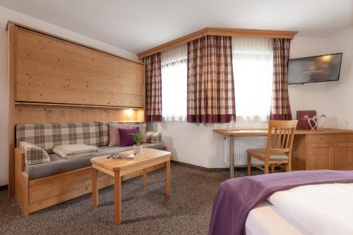 a hotel room with a couch and a table at Hotel Salzburgerhof in Flachau