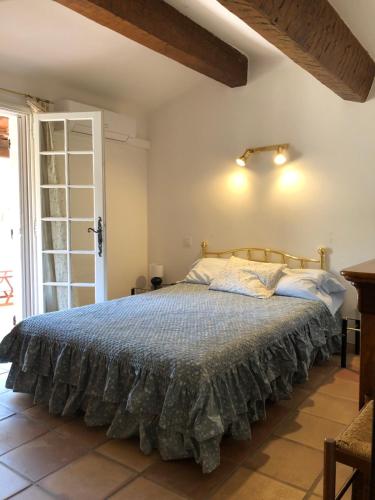 BelgentierにあるVilla provençale au calme entourée de verdure, animaux de compagnie acceptés !の青い掛け布団が敷かれたベッドのある寝室