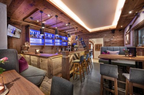a bar in a restaurant with tables and chairs at Hotel Salzburgerhof in Flachau