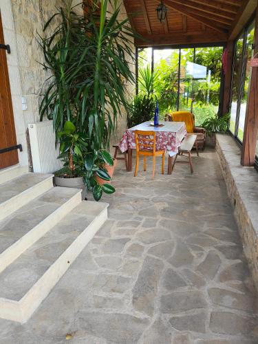 a patio with a table and chairs and plants at le gîte du lac in Quatre-Routes