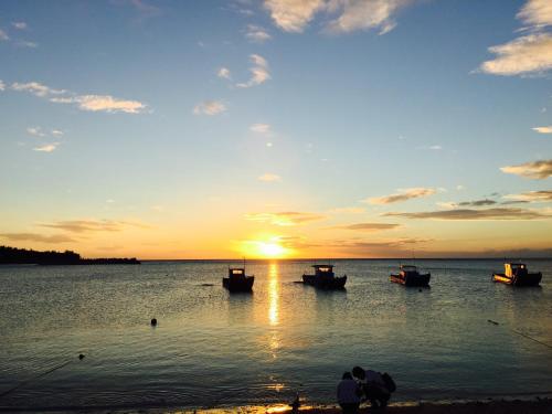 a group of boats in the water at sunset at Doll House Lodge in Hengchun