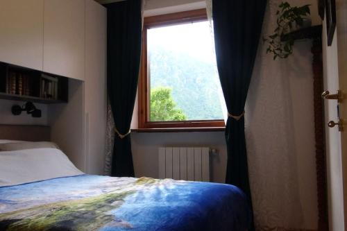 a bedroom with a bed and a window at Chalet Belvedere in Costa di Serina