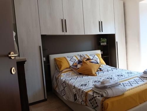 a bedroom with a bed with white cabinets and yellow pillows at La casina in Caprarola