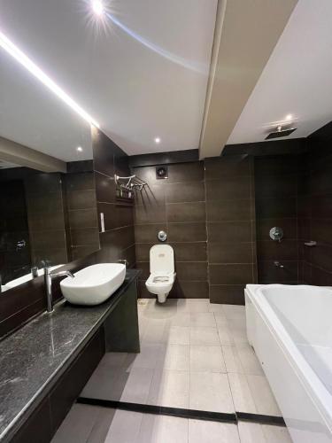 a bathroom with a sink and a toilet and a tub at Hotel Merakee - Near Dahisar Mira Road Mumbai in Mumbai