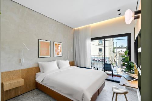 a bedroom with a white bed and a large window at Hotel 48 in Beer Sheva