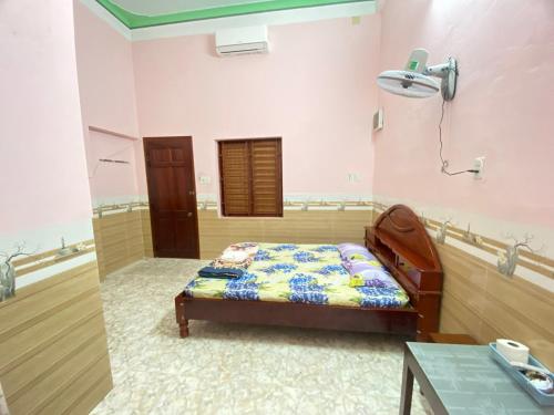 a bedroom with a bed and a table in it at Nhà nghỉ Thanh Mai in Quang Ngai