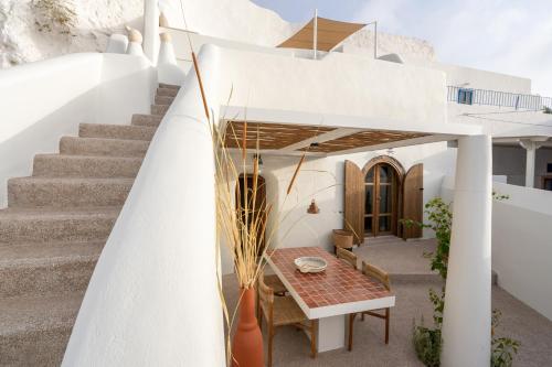 a white house with a table and stairs at Kanava Cave Winery Villa in Mesaria