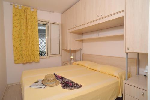 a bedroom with a bed with a hat on it at Residence Le Orchidee in Vieste