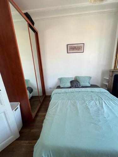 une chambre avec un lit et un miroir dans l'établissement Appartement Boulogne Rolland-Garros, à Boulogne-Billancourt