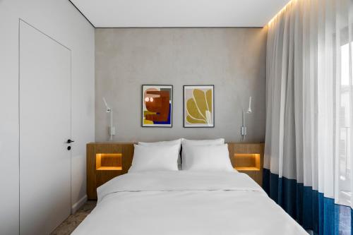 a bedroom with a large white bed and a window at Hotel 48 in Beer Sheva