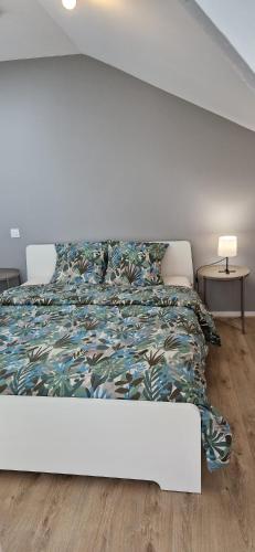 - une chambre blanche avec un lit et un couvre-lit coloré dans l'établissement A 2 pas de la BASILIQUE, à Bourg-en-Bresse