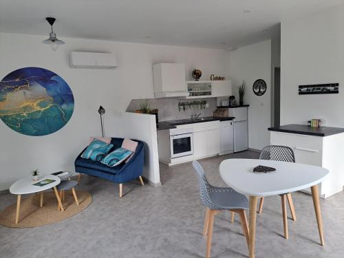 un salon avec une chaise bleue et une table dans l'établissement A la source, à Saint-Médard-de-Guizières