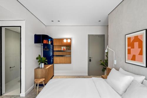 a bedroom with a white bed and a closet at Hotel 48 in Beer Sheva