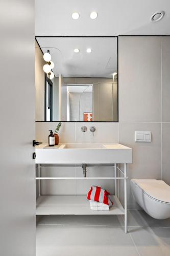 a bathroom with a sink and a toilet and a mirror at Hotel 48 in Beer Sheva