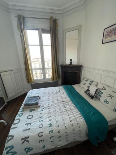 une chambre avec un grand lit et une fenêtre dans l'établissement Appartement Boulogne Rolland-Garros, à Boulogne-Billancourt