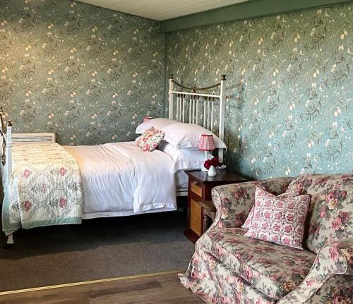 a bedroom with a bed and a couch at Country garden lodge on Devon Cornwall border in Lifton
