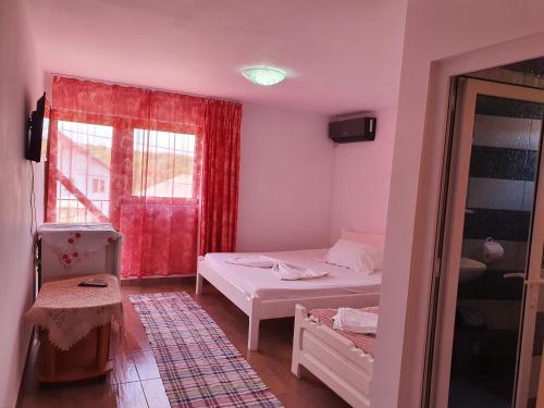a small room with a bed and a window at Camere de închiriat Alex in Costinesti