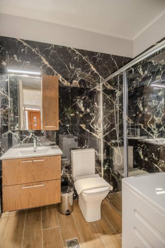 a bathroom with a toilet and a sink at Dionysis Elegant Cozy Apartment in Filiatra