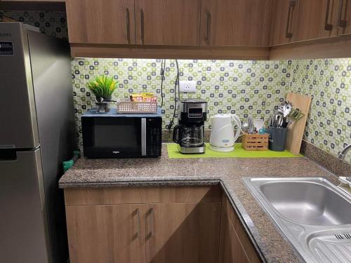 a kitchen counter with a microwave and a sink at MaRoy Suites at Asteria Residences (Near NAIA with free Parking+Fiber Internet) in Manila