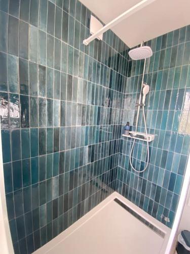 une salle de bain avec douche aux carreaux bleus dans l'établissement Appartement Océane terrasse panoramique, à Saint-Palais-sur-Mer