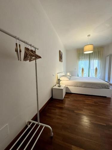 a white bedroom with a bed and a window at Fontana Apartment in Perugia