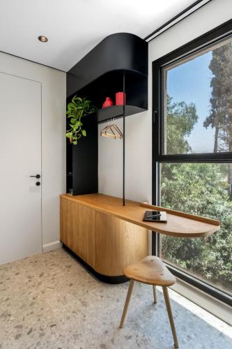 a home office with a wooden desk and a window at Hotel 48 in Beer Sheva