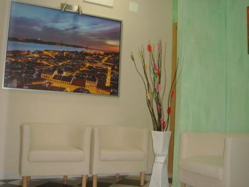 a waiting room with two chairs and a picture of a city at DownTown Guest House in Lisbon