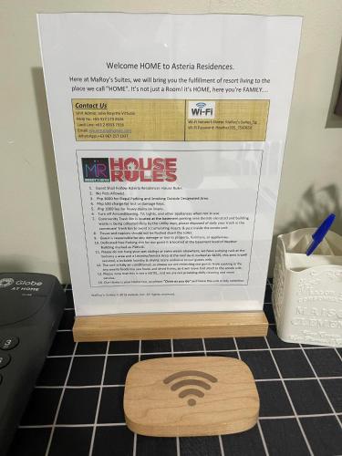 a sign sitting on top of a kitchen floor with a table at MaRoy Suites at Asteria Residences (Near NAIA with free Parking+Fiber Internet) in Manila