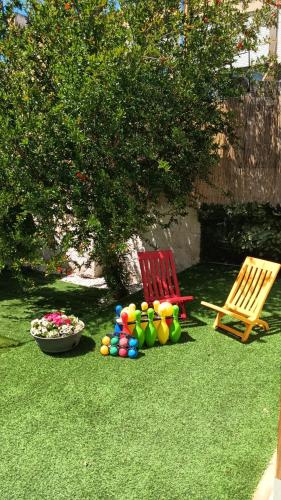 two chairs and a pile of balls on the grass at L’angolo rosa in Carosino