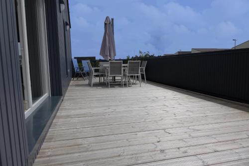 a deck with chairs and an umbrella on a house at ATELIER DE BERCK - Chambres d'hôtes in Berck-sur-Mer