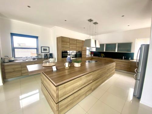 a large kitchen with a large wooden counter top at Summer Place Dolphin Beach in Rand Rifles