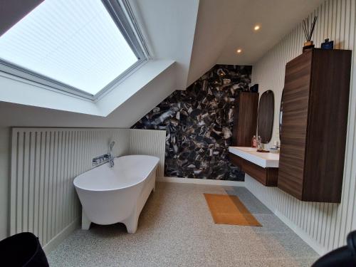 a bathroom with a large tub and a skylight at ATELIER DE BERCK - Chambres d'hôtes in Berck-sur-Mer