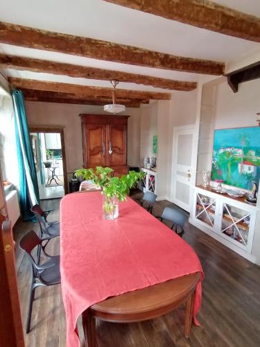 une salle à manger avec une table rouge avec un vase dessus dans l'établissement La Tocade Del Arte - Dinan, à Lanvallay