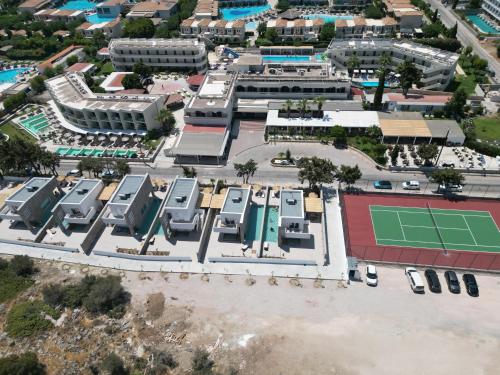 an aerial view of a parking lot with a tennis court at Delfinia Resort - All Inclusive in Kolymbia