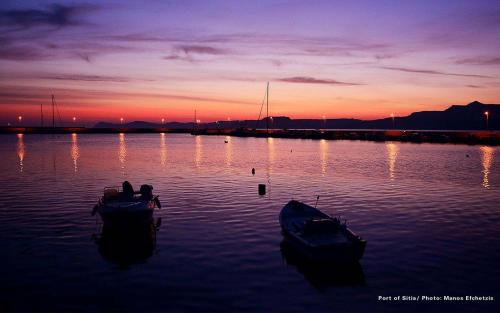 a couple of boats in the water at sunset at Bougainvillea Apartment in Petrás