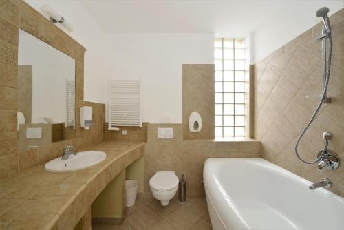 łazienka z wanną, umywalką i toaletą w obiekcie Semiramis Business Hotel w mieście Szolnok