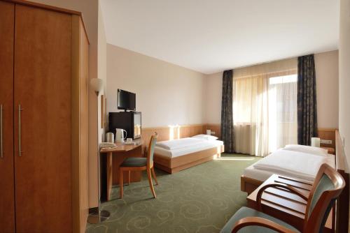 A bed or beds in a room at Semiramis Business Hotel