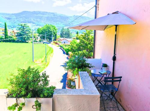 a patio with a table and an umbrella at Verdeacquassisi in Rivotorto 