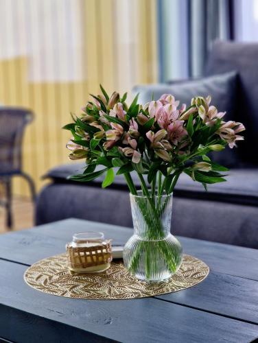 a vase of flowers sitting on a table at Atpūtas Comfort Cabin House in Kalngale