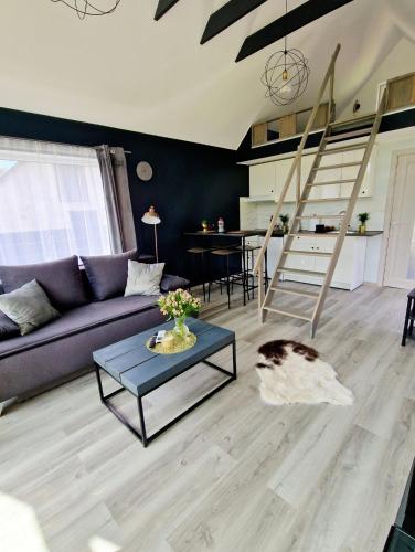 a living room with a couch and a table at Atpūtas Comfort Cabin House in Kalngale