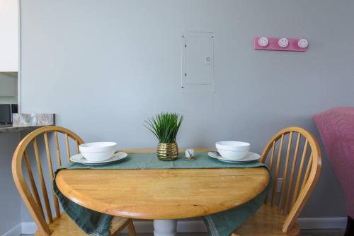 a wooden table with two bowls and a plant on it at New cozy coastal retreat! in Groton