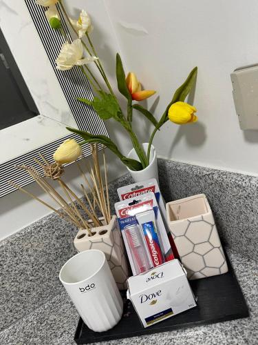 a tray with books and a vase with flowers at MaRoy Suites at Asteria Residences (Near NAIA with free Parking+Fiber Internet) in Manila