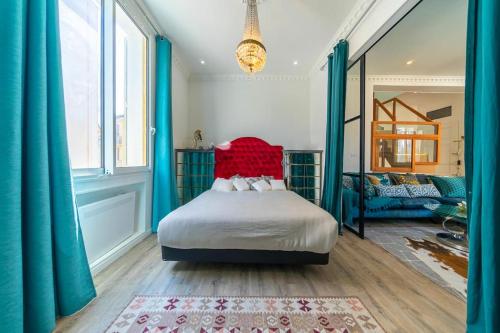 a bedroom with a bed with blue curtains and a red headboard at Elegant duplex, very well equipped, close to shops in Cannes