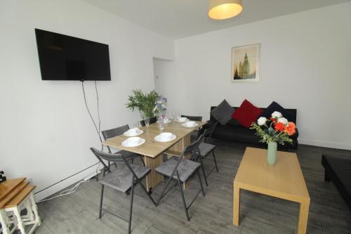 a living room with a table and a couch at High Street House Thurnscoe by Smart Corporate Stays in Barnsley