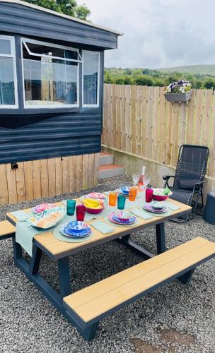 a picnic table with plates of food on it at Mobile Holiday Home in Cushendall