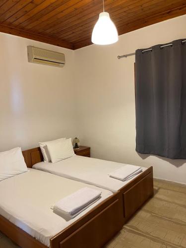 a bedroom with two beds and a ceiling at Zaga Apartments - Flats in Koroni