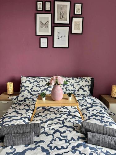 a bedroom with a bed with a vase on a table at Clydebank Cozy 3bdr flat near Glasgow in Clydebank
