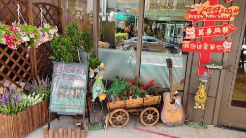 a store front with a display of flowers and guitars at HopeCity MinSheng Hotel in Taipei