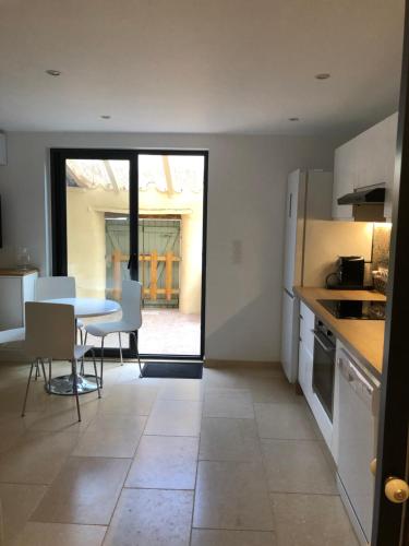 une cuisine et une salle à manger avec une table et des chaises dans l'établissement T2 cosy tout équipé avec terrasse plancha, à Montauroux